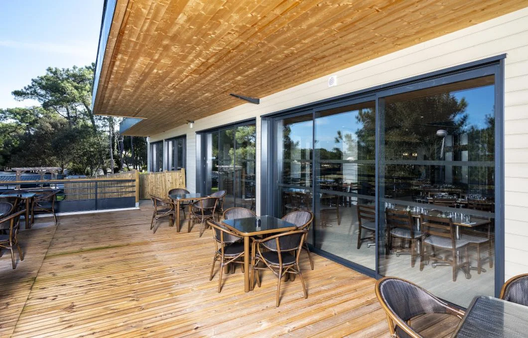 Grande baie vitrée coulissante donnant sur une terrasse en bois abritée à La Souterraine