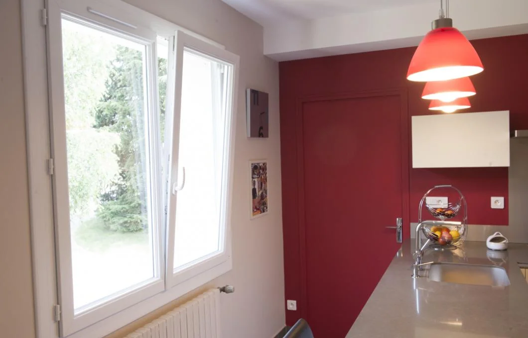 Fenêtre PVC blanche remplacée dans une cuisine rénovée aux murs bordeaux à La Souterraine