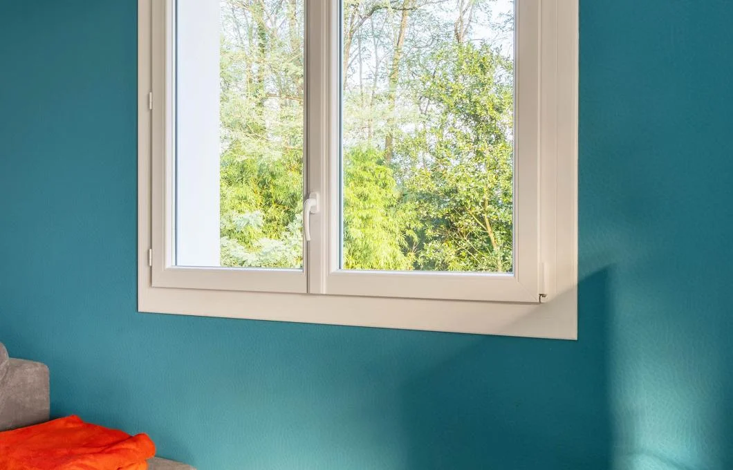 Fenêtre PVC blanche à deux vantaux et double vitrage installée dans une pièce à vivre à La Souterraine