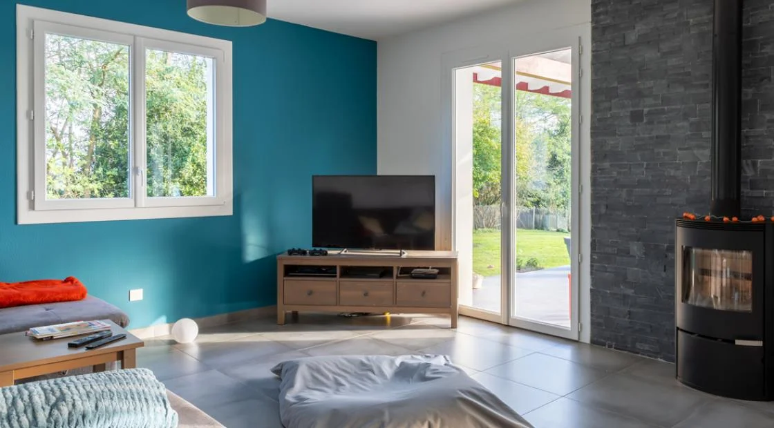 Fenêtre PVC blanche et porte-fenêtre dans un séjour équipé d'un poêle à bois à La Souterraine