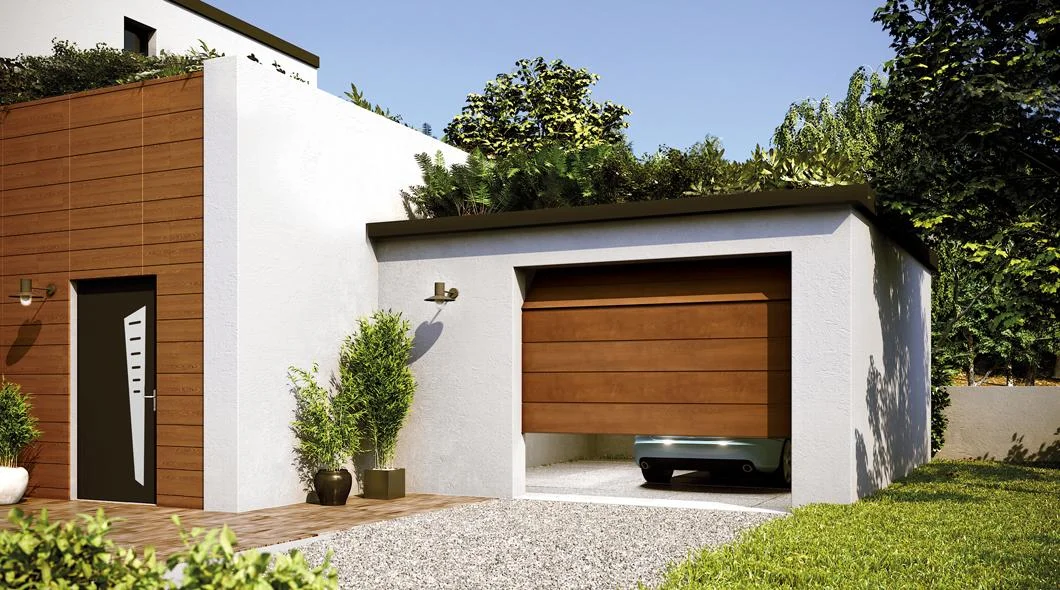Porte de garage sectionnelle finition bois sur un garage contemporain à toiture végétalisée, à La Souterraine